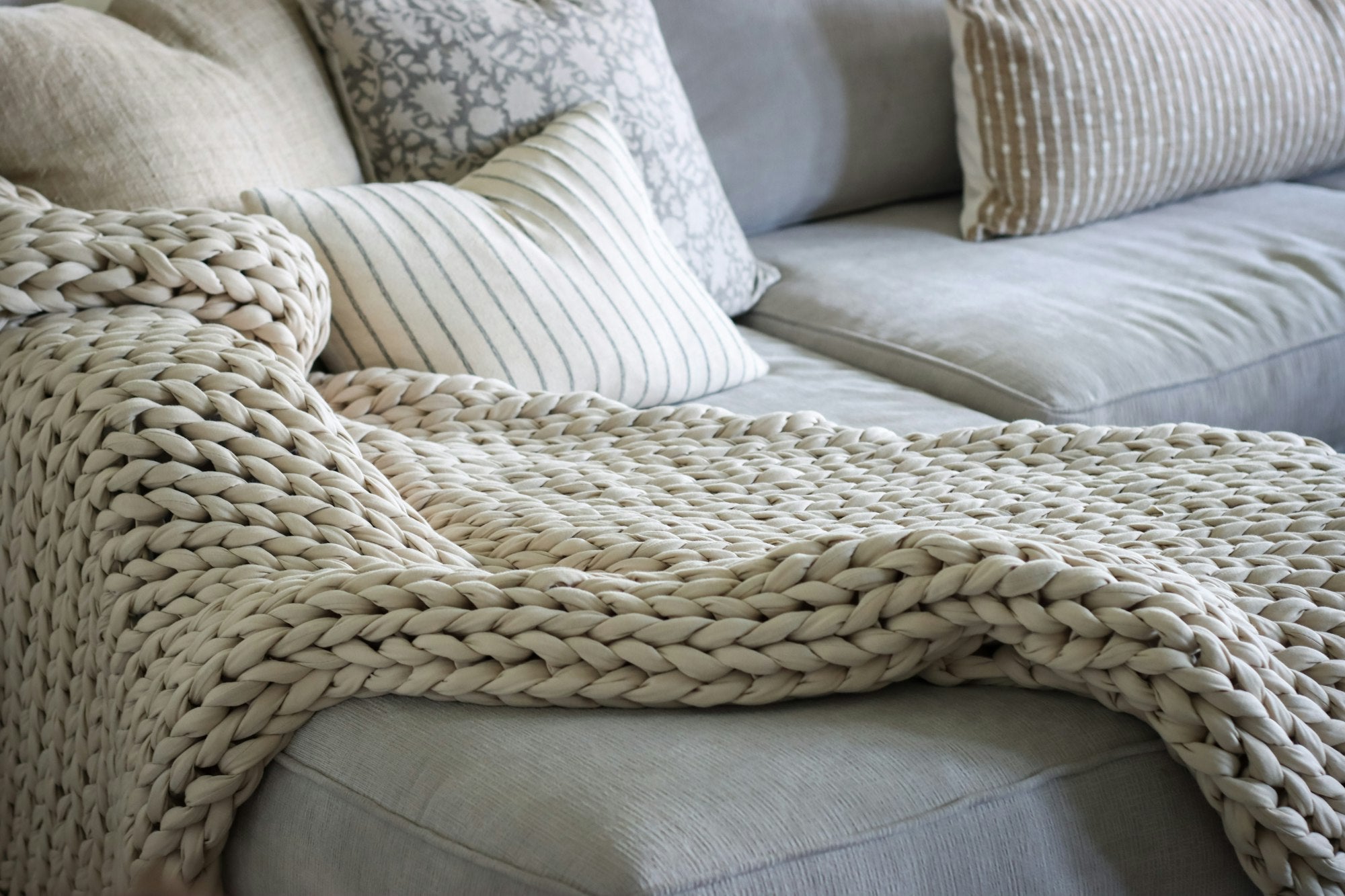 Grovstrikket plaid på sofa